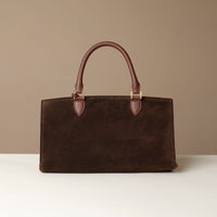 Brown suede leather Danilos handbag on a beige background