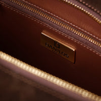 Close-up of a brown leather bag with a gold zipper and visible Danilos logo.