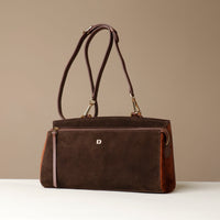 Brown suede Danilos handbag with strap and a visible brand logo on a beige background