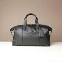 Black leather travel bag on a beige background