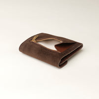 Brown suede wallet with gold zipper opened on a light beige background