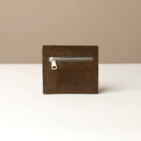 green suede wallet with a zipper on a beige background