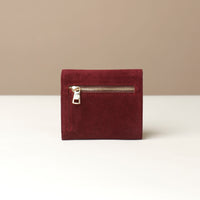 Red wallet with a zipper on a beige background
