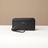 front view of a black Danilos wallet Carlota with a visible handle drop in a beige background