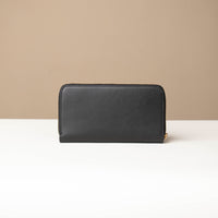 Back view of a black Danilos wallet Carlota in a beige background