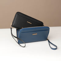 front view of a black and blue Danilos wallet Carlota with a visible handle drop in a beige background