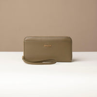front view of a green Danilos wallet Carlota with a visible handle drop in a beige background