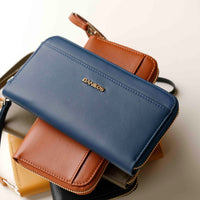 upper view of a blue and brown Danilos wallet Carlota with a visible handle drop in a beige background