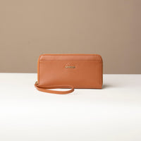 front view of a light brown Danilos wallet Carlota with a visible handle drop in a beige background